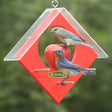 Duncraft Apple Kabob Feeder with two birds feeding on fruit skewered in the center, protected by a clearview plastic weather guard and featuring six metal perches.