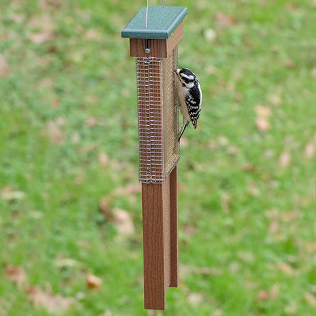 Pileated Woodpecker Suet Shield Wrap Feeder with a woodpecker feeding from the wire mesh grid, preventing larger birds and squirrels from stealing suet.