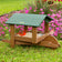 Duncraft Covered Garden Cart Platform Feeder with seed, hosting a Northern Cardinal, Chickadee, and finch, set against vibrant garden flowers.