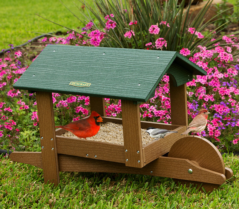 Duncraft Covered Garden Cart Platform Feeder with perched red cardinal, featuring a durable, decorative design and overhanging roof, ideal for attracting birds year-round.