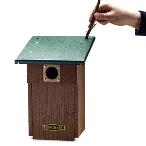 Person holding a stick to the Duncraft Bluebird Landing View House & Pole, showcasing the birdhouse's perching feature and supporting hand detail.