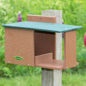 Duncraft Bird-Safe® Cardinal Hide-A-Way: A bird feeder on a wooden post, featuring fly-through openings and a lookout area, ideal for cardinals, robins, and Mourning Doves.