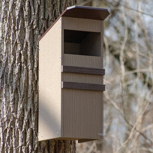 Duncraft Screech Owl Nesting Box mounted on a tree, featuring a slotted entry hole, ventilation, drainage, and fledgling ladder.