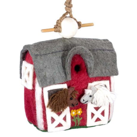 Woolie Country Stable Bird House: A handmade, wool birdhouse resembling a red and white barn, complete with horses and a white ball, featuring a jute cord and bamboo perch.