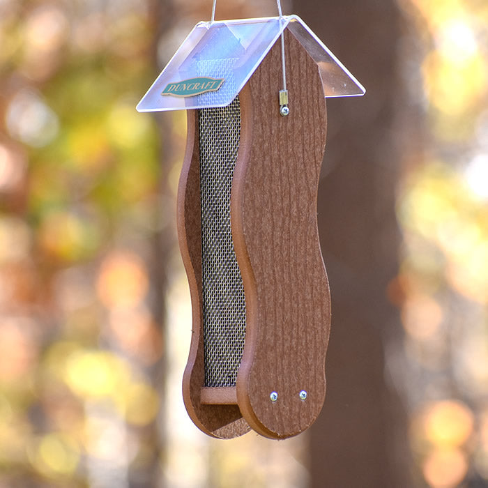 Duncraft Wave Mesh Nyjer® Feeder hanging from a tree, featuring a clearview plastic roof and durable brown recycled plastic with clinging mesh for finches.