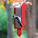 Duncraft Red Arrow Tail Prop Double Suet Feeder with a woodpecker clinging to the wire grid, feeding on a suet cake outdoors.