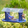 Duncraft Bluebird Cafe Feeder with bluebirds feeding on mealworms, featuring four perches and plexiglass sides to protect food, set in a garden.