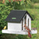 Duncraft Contemporary Farmhouse Feeder with black roof, clear windows, and two trays, hosting an American goldfinch, female Northern Cardinal, and sparrow.