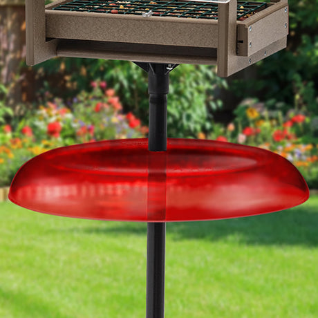 Duncraft Pole Baffle, Red - Made in the USA, shown as a red disc designed to squirrel-proof pole-mounted bird feeders and birdhouses.