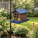 Barn bird feeder with seed and birds hanging form a pole in the backyard. 