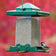 Vista Squirrel-Resistant Feeder with green top and clear sides, featuring a chickadee on the ledge, showcases adjustable perches and weather protection.