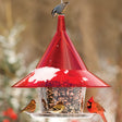 Arundale Ruby Sky Cafe bird feeder with snow, hosting a goldfinch, pine siskin, cardinal, and nuthatch. Features a red roof, wide seed tray, and anti-squirrel design.