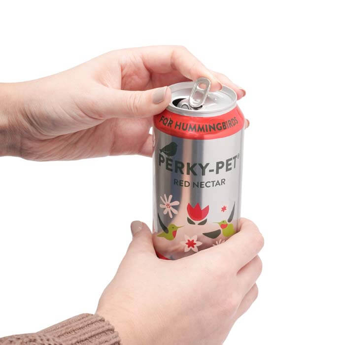 Perky-Pet® Ready-To-Use Red Hummingbird Nectar, 16 oz., shown being held and opened by a person, packaged in an easy-to-use aluminum can.