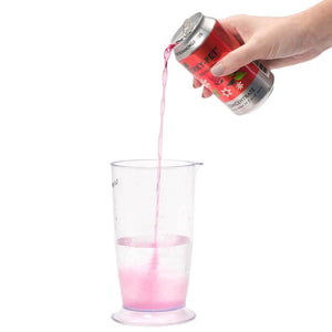 Hand pouring Perky-Pet® Red Hummingbird Nectar Concentrate from a 12 oz. aluminum can into a glass, demonstrating easy mixing for bird-friendly nectar.