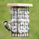 Duncraft Hanging Nesting Basket with a chickadee extracting soft cotton fiber for nest building, featuring a wire cage and wooden roof.