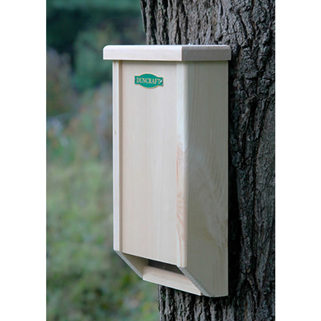 Duncraft BestBasic Bat House mounted on a tree, showcasing its wooden structure and mesh screening for easy bat landing and roosting.