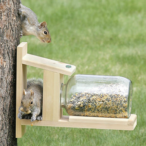 Duncraft Squirrel Jar Feeder: A squirrel climbs a tree, eating from a jar feeder designed to hold peanuts, Wildlife Snack, or corn, providing hours of entertainment.