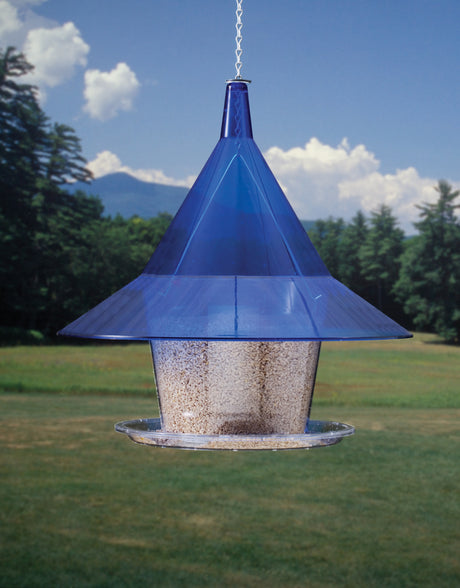 Arundale Sapphire Sky Cafe bird feeder with a blue cone-shaped baffle and see-through hopper, hanging from a chain, designed to prevent squirrels from accessing the seed.