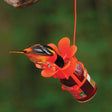 Jelly/Jam Fruit Feeder with a bird eating from an attached jelly jar, featuring a built-in perch on an orange blossom-shaped base.