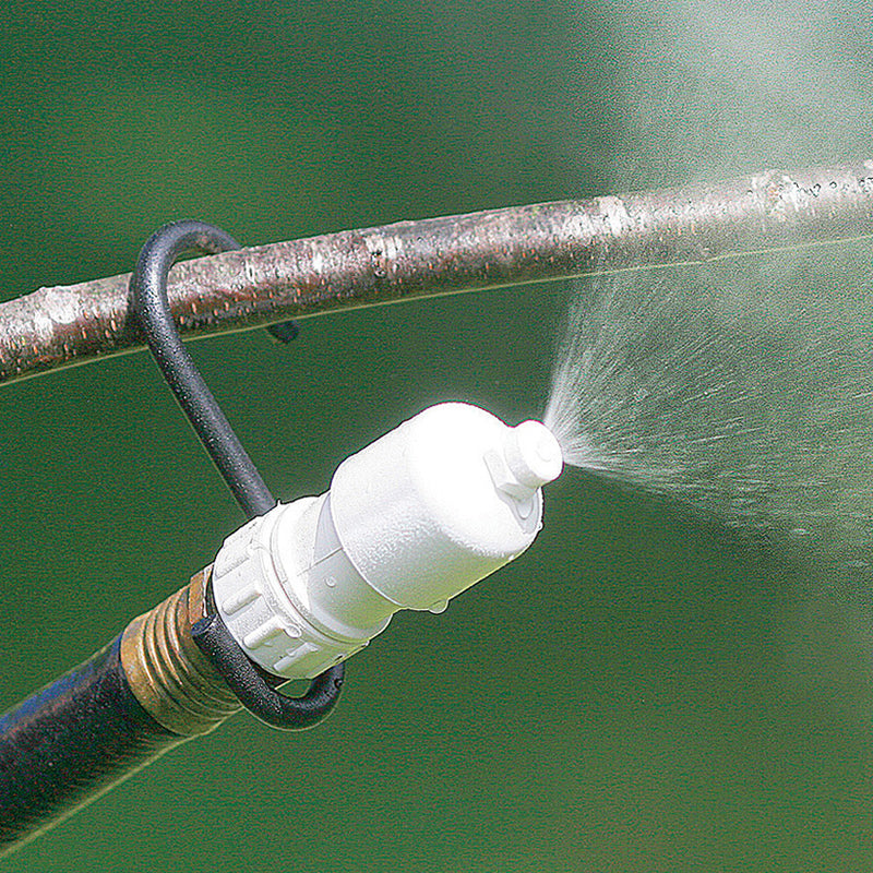 Super Easy Water Mister spraying water onto a tree branch, easily attaches to a garden hose, includes S-hook for versatile placement.