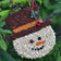 Frosty Christmas Cookie — Holiday Seed “Cookie” for Birds: Snowman-shaped bird feeder with seed coat, apricot nose, blueberry eyes, and red raffia hanger for trees.