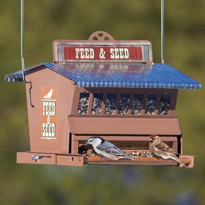 Rustic Farmhouse Absolute® Feed & Seed Squirrel-Resistant Feeder with birds perched, showcasing a tilting perch and steel construction with a corrugated roof.