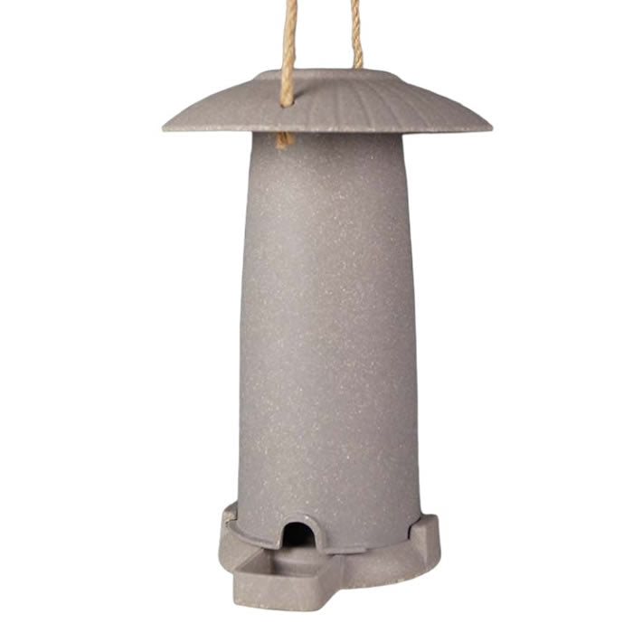 Earthy Seed Feeder made from nut husks or straw, featuring a roof, cylindrical shape, and twine hanger, perfect for attracting birds year-round.