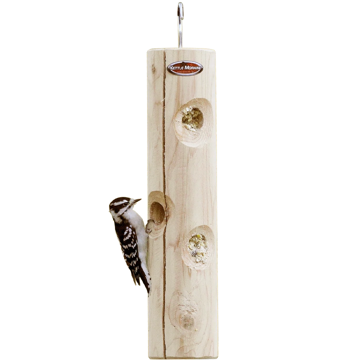 Hanging cedar suet log feeder with a downy woodpecker feeding from recessed suet holes.