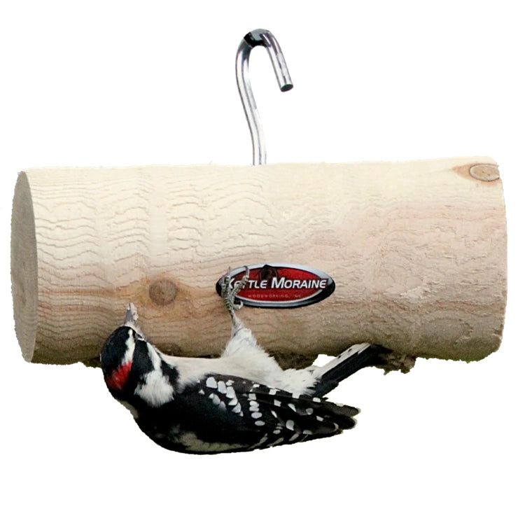 Natural log suet feeder hanging from a hook with a downy woodpecker clinging underneath.