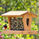 Rose-breasted grosbeak perched on a large-capacity cedar hopper bird feeder filled with mixed seed.