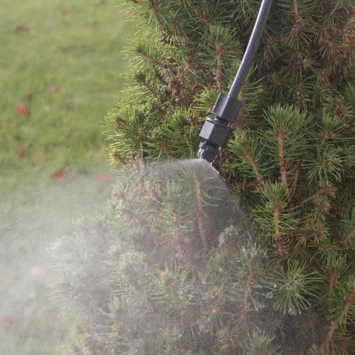 Leaf Mister gently spraying fine mist over a tree, attracting birds and ensuring foliage hydration. Includes tubing, nozzle, regulating valve, and faucet fitting.