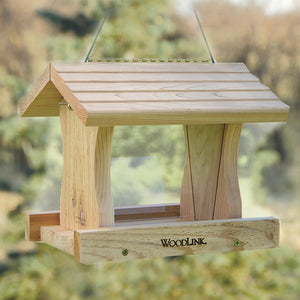 Deluxe Cedar Hopper Feeder with a wooden structure, roof, two feeding trays, clear plastic sides, and cable hanger, designed to resist insects and decay.