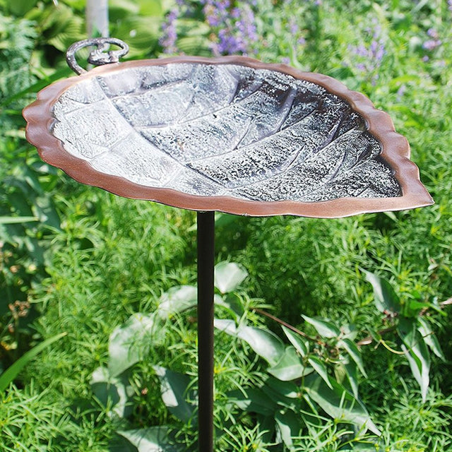 Aspen Leaf Bird Bath with Stake in a garden setting, featuring an embossed basin for birds' footing, atop a 36-inch wrought iron stake.