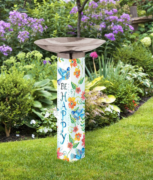 Happy Bluebirds Bird Bath in a garden, showcasing bird and flower illustrations on a white post with a copper-plated, hand-hammered basin.