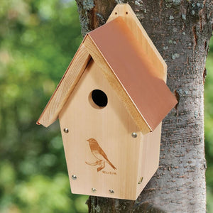 Coppertop Cedar Bluebird House mounted on a tree, featuring a decorative laser-etched bluebird design and a copper roof for heat deflection.