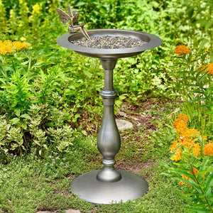 Decorative bird bath with fairy figure in a garden setting