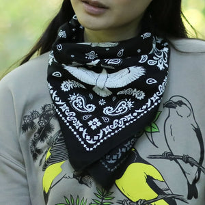 Bird Collective Hawks In Flight Bandana showcased by a woman wearing it around her neck, highlighting hawks in flight design. Ideal for bird enthusiasts and nature lovers.