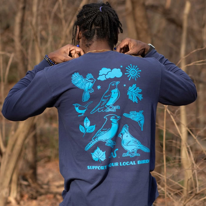 Person wearing Bird Collective Bird Friends Long Sleeve T-Shirt with bird illustrations, showcasing a passion for birdwatching and nature.