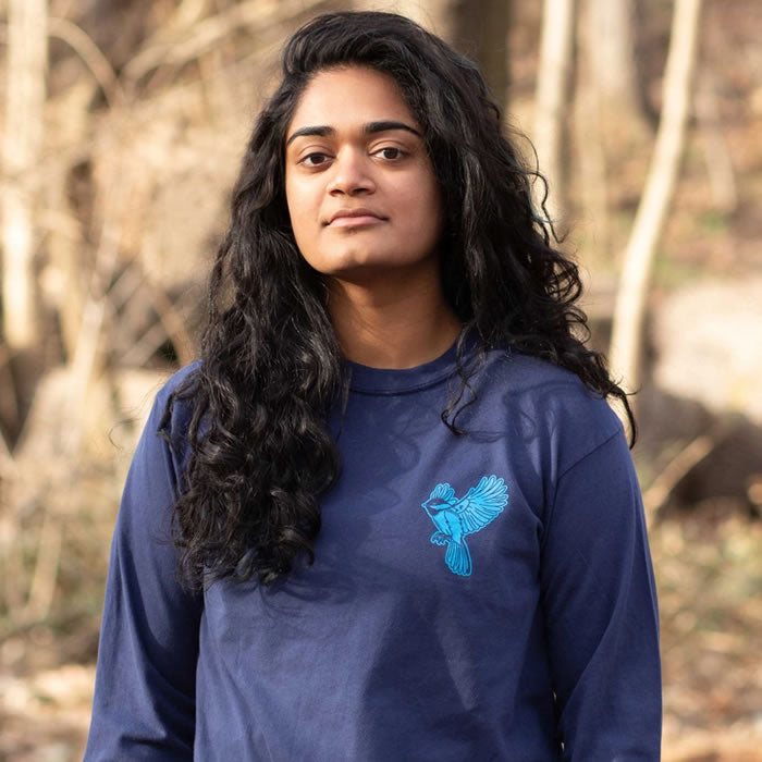 Woman wearing Bird Collective Bird Friends Long Sleeve T-Shirt featuring intricate bird designs, showcasing the shirt's fit and style.