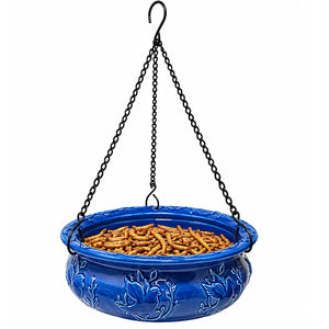Blue ceramic hanging bird feeder filled with dried mealworms to attract bluebirds, chickadees, wrens, and other insect-eating backyard birds.