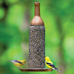 Mesh Wine Bottle Bird Feeder with copper finish, features a metal mesh tube filled with seeds, supporting two goldfinches on its tray.