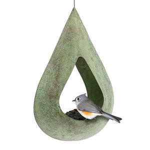 Rain Drop Fly-Thru Verde Copper Bird Feeder with weathered patina, filled with sunflower seeds, a tufted titmouse perches, showcasing its tear-drop design and stainless steel mesh.