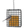 A black metal hanging bird feeder cage with a yellow seed block inside, shown against a white background with a small bird perched on the front.