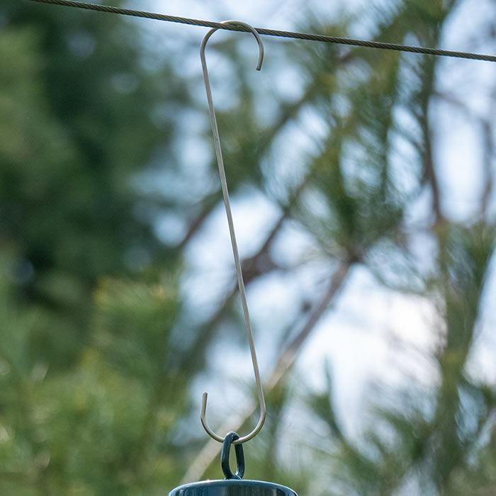 Brome Stainless S-Hooks for hanging bird feeders, shown attached to a tree branch. Available in five lengths, these hooks fit branches up to 1 inch wide.