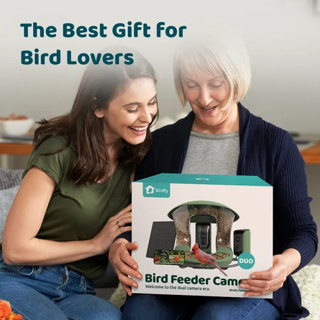 Two smiling women hold a Birdfy Feeder 2 Duo box, showcasing its dual-camera bird feeder as the perfect gift for bird enthusiasts.