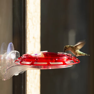 3-in-1 Hummingbird Feeder with a red lid, clear basin, and three feeding stations. Includes window mount, hanging hook, and garden stake for versatile placement.