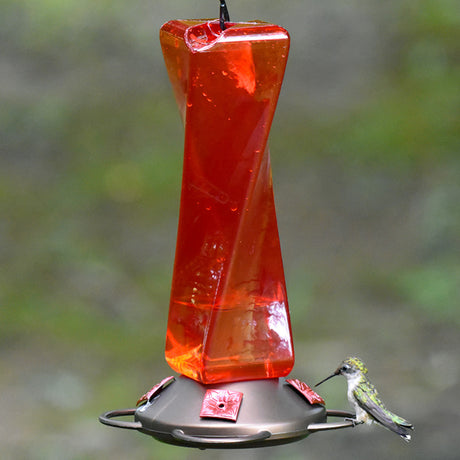 Mirage Hummingbird Feeder with four red flower feeding stations and a see-through plastic reservoir, featuring a perched hummingbird feeding.