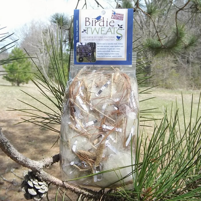 Chickapea Farms Birdie Tweats Nesting Material bag displayed outdoors on a branch, showcasing natural materials for bird nests.