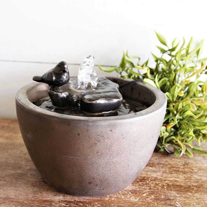 Sparrow On Leaf Fountain: A tabletop water fountain with a bird perched on a leaf, bubbling water over pebbles into a bowl below.