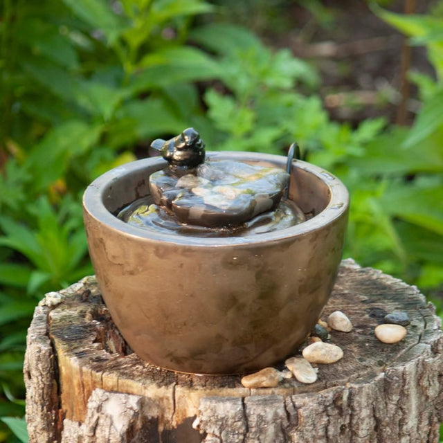 Sparrow On Leaf Fountain: A tabletop ceramic fountain with a bird statue perched on a leaf, water bubbling over pebbles in a bowl.